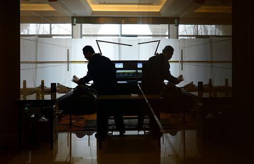 2013年“两会”期间,由中国民族语文翻译局着手组建的大会秘书处民族语文翻译组,让少数民族代表委员能够用本民族语言履行职责、参政议政,及时把党和国家的声音传递到民族地区和少数民族干部群众中。截至3月14日,翻译组已用7种少数民族文字翻译了人大会议文件45份,政协会议文件13份,委员发言33份,翻译字数达220.2万字;用7种少数民族语言为大会会场提供同声传译14次,共计同传54.6万字;完成16000份民族文文件的印制工作,与汉文文件同步提供给少数民族代表和委员。同时,翻译组还担负着向新华社、中央人民广播电台、中国国际广播电台以及8个省、自治区的25家地方新闻媒体提供大会主要文件民族文译稿的任务。3月15日,工作人员将印刷完毕的大会文件做裁边处理。新华社记者 金良快 摄