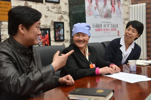 马玉花(中)在北京市丰台区蒲黄榆社区卫生服务中心与该中心工作人员交流(3月12日摄)。新华社记者 王鹏 摄