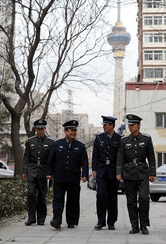 3月2日,全国人大代表、北京保安服务总公司海淀保安分公司经理助理朱良玉(左二)在海淀区一个居民小区与几名保安交谈。新华社记者 罗晓光 摄