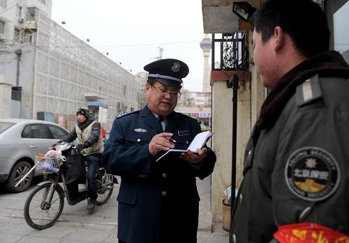 3月2日,全国人大代表、北京保安服务总公司海淀保安分公司经理助理朱良玉(左二)在海淀区一个居民小区做调研。新华社记者 罗晓光 摄