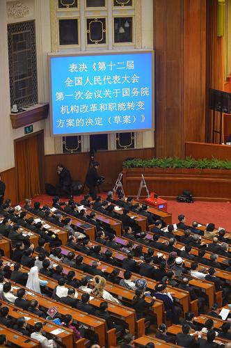 十二届全国人大一次会议举行第四次全体会议 3月14日,十二届全国人大一次会议在北京人民大会堂举行第四次全体会议,选举第十二届全国人民代表大会常务委员会委员长、副委员长、秘书长;选举第十二届全国人民代表大会常务委员会委员;选举中华人民共和国主席、副主席;选举中华人民共和国中央军事委员会主席。这是代表表决关于国务院机构改革和职能转变方案的决定。 新华社记者王颂摄