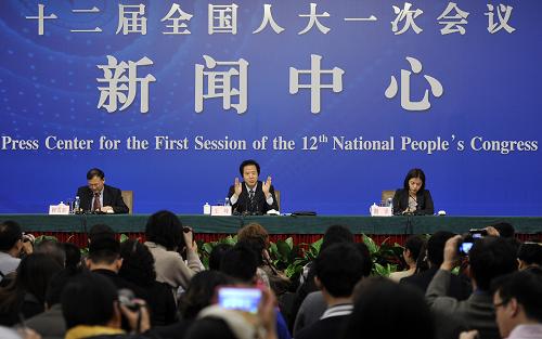 3月11日,十二届全国人大一次会议在两会新闻中心举行记者会。中央机构编制委员会办公室副主任王峰(中)就《国务院机构改革和职能转变方案》有关内容和考虑回答记者提问。