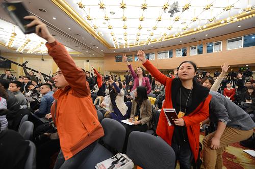 3月7日,全国政协十二届一次会议在两会新闻中心举行记者会,政协委员贾治邦、陈锡文、厉以宁、李毅中、杜鹰、林毅夫就推动科学发展回答记者提问。这是记者举手争取提问机会。 新华社记者 秦晴 摄