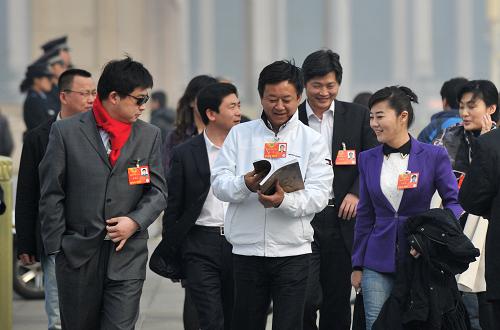 3月7日,全国政协十二届一次会议在北京人民大会堂举行第二次全体会议。这是全国政协委员朱军(中)等抵达天安门广场。新华社记者 郭晨 摄