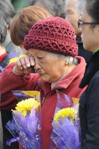 12月13日,南京大屠杀幸存者仇秀英老人在侵华日军南京大屠杀中山码头遇难同胞纪念碑前参加悼念活动。新华社记者 孙参 摄