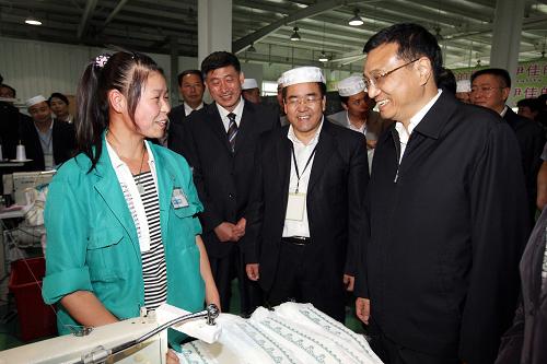 8月23日至25日,中共中央政治局常委、国务院副总理李克强在青海考察。这是8月23日,李克强在青海伊佳民族服饰有限责任公司考察时与女工交谈。新华社记者 姚大伟 摄