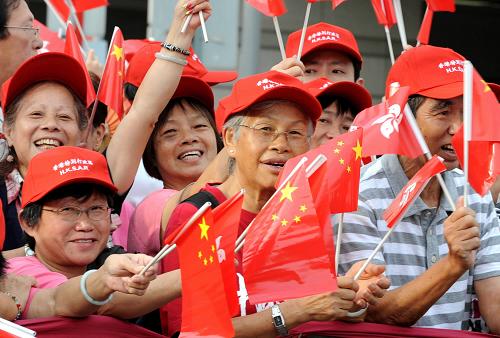 这是香港市民和游客观看升旗仪式。 新华社记者 宋振平 摄