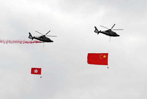 10月1日,香港特别行政区在金紫荆广场举行升旗仪式,庆祝中华人民共和国成立60周年。这是两架分别悬挂中华人民共和国国旗、香港特区区旗的直升机从空中飞过。 新华社记者 陈铎 摄