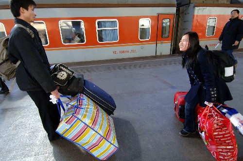 2月3日,在北京火车站,旅客拖着行李准备上车. 新华社记者 李文 摄