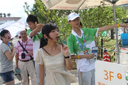 8月9日,在上海世博园内,两名"小白菜"在为游客指路.