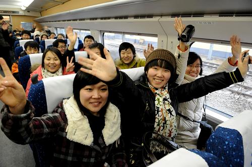 2月6日,旅客在郑州开往西安G2003次“和谐号”动车组列车上向记者招手致意。当日,中国中西部第一条高速铁路郑州至西安高速铁路正式投入运营。郑州至西安高速铁路全长505公里,列车运营时速350公里,开通后列车直达最短时间由6个多小时缩短至2小时以内。新华社记者 朱祥 摄