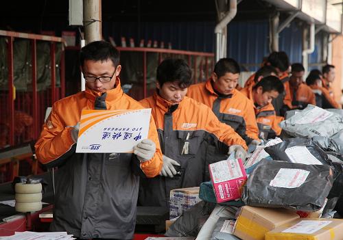 11月10日,在山东省滕州市申通快速递中心,快递工作人员在分拣包裹.