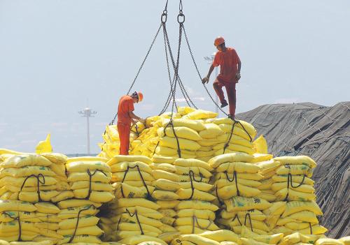 7月13日,工人在江苏连云港港口码头装卸出口货物.新华社发(耿玉和 摄)