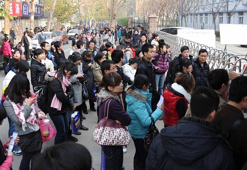 12月5日,在国家公务员考试济南第六十八中学考点,考生们等候进入考场。 当日,2011年度中央机关及其直属机构公务员考试录用公共科目笔试在全国31个考区的46个城市同时举行。据了解,今年全国有140万人同时走进考场,而山东省参加国家公务员考试的人数超过了10万人。 新华社记者 徐速绘 摄