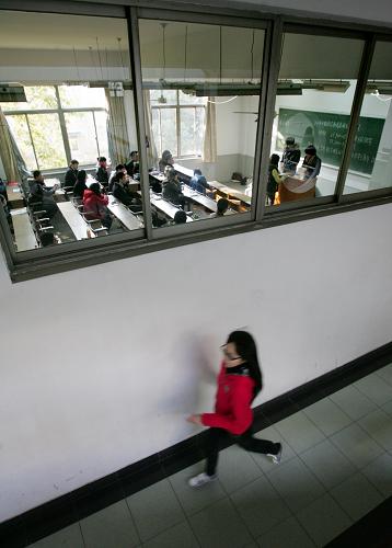 12月5日,在2011年度中央机关及其直属机构招录公务员考试浙江大学西溪校区考点,一名考生急匆匆走过一考场。当日,2011年度中央机关及其直属机构招录公务员考试的公共科目笔试在全国31个省(区市)同时举行,考试科目包括行政职业能力测试和申论两科,全国报名总人数突破140万。据了解,本次考试浙江24个考点全部设在杭州,约6万名考生参加考试。新华社发(吴煌 摄)