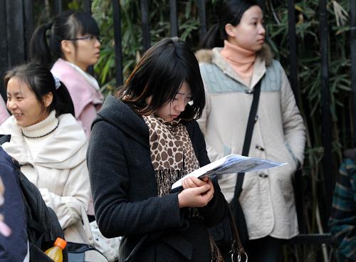 12月5日,在南京女子中专考点,参加国家公务员考试的考生在等候进场时抓紧复习。 当日,2011年度中央机关及其直属机构招录公务员考试的公共科目笔试在全国31个省(区市)同时举行,考试科目包括行政职业能力测试和申论两科,全国报名总人数突破140万。据了解,此次考试江苏省分别在4个考区南京、无锡、徐州、扬州设立了46个考点,考生总数达62182人。 新华社记者 孙参 摄