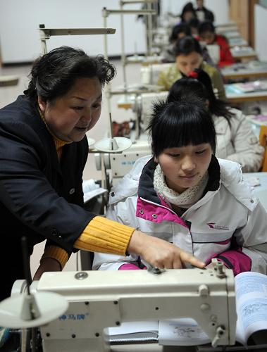 返乡农民工正在永川区举办的免费培训班上缝纫课(2月5日摄)。永川区是重庆市劳务输出大区,截至2月1日,返乡的农民工达5万多人,针对返乡农民工增加的势头,永川区各级部门加大培训返乡农民工的力度,他们开设了理论和实践课程,电工、缝纫、厨艺等实用技术课程深受返乡农民工的欢迎。新华社记者 李晓果 摄