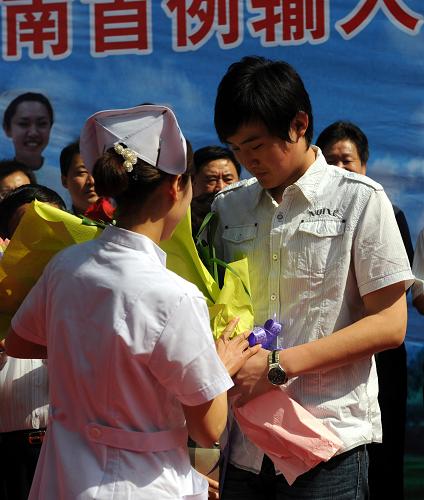 5月19日,医务工作者向中国内地第2例甲型H1N1流感患者吕某(前右)献花祝贺出院。当日,中国内地第2例甲型H1N1流感患者吕某从济南市传染病医院康复出院。吕某于5月11日晚进入济南市传染病医院开始接受治疗,经过卫生部、山东省的医疗专家精心细致的治疗,已治愈康复,符合出院条件。新华社记者 范长国 摄