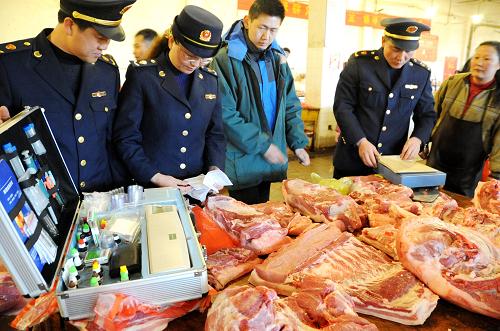 3月23日,连云港工商执法人员在农贸市场检查商贩出售猪肉的检疫凭证。连日来,江苏连云港工商局开展“严查猪肉保民生”执法行动,对辖区集贸市场、超市出售的猪肉进行拉网式检查,重点检查病死畜禽非法交易、私屠滥宰、使用瘦肉精等禁用物质以及注水等违法行为,切实维护猪肉市场消费安全,让市民吃上“放心肉”。新华社发(王春 摄)