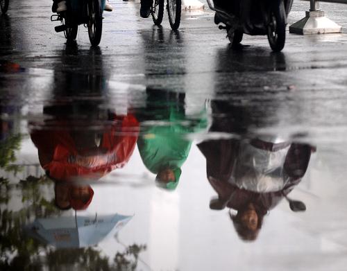 9月13日,郑州市民冒雨骑行。 连日来,河南全省境内连续出现阴雨,气温有所下降,据预报未来三天仍将维持阴雨天气。新华社记者 朱祥 摄