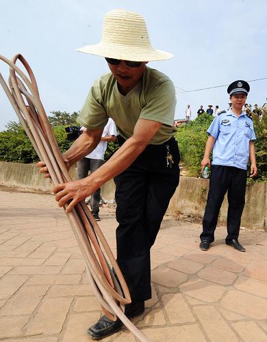 6月22日,工作人员正拆除湘江长沙段非法餐饮船聚集地所使用的一自来水管。 当日,长沙市环保局、海事局、畜牧水产局、城管局、公安局等多个政府部门组成的联合执法组对湘江长沙段猴子石大桥附近水域非法经营的餐饮船开展了清理整治工作。据悉,湘江长沙段非法餐饮船已存在多年,政府有关部门也曾多次采取行动,但一直未得到有效根治。据了解,湘江长沙段非法经营的餐饮船最多时达到百余艘。这些餐饮船大部分没有营业执照、卫生许可证和排污证等,既污染湘江水质,更阻碍湘江江水畅流,给当地防汛抗洪以及交通航运带来安全隐患。 新华社记者 龙弘涛 摄