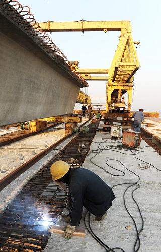 12月6日,建设者在临洪河特大桥施工现场作业。新华社发(耿玉和 摄)