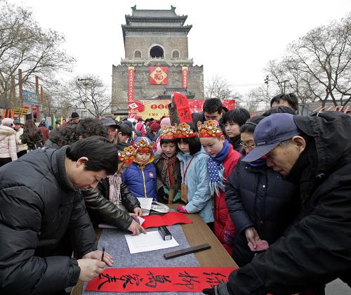 2月6日,在北京钟鼓楼广场举行的“文明春联进万家”活动上,书法家为社区居民写春联。当天是农历腊月二十三,是中国传统的“小年”。北京市东城区“文明春联进万家”活动在钟鼓楼广场举行,展出从600余副春联中评选出的20副优秀原创文明春联。多位书法家在现场挥毫泼墨,书写春联赠送社区居民,为即将到来的春节增添喜庆。新华社发(江峻 摄)