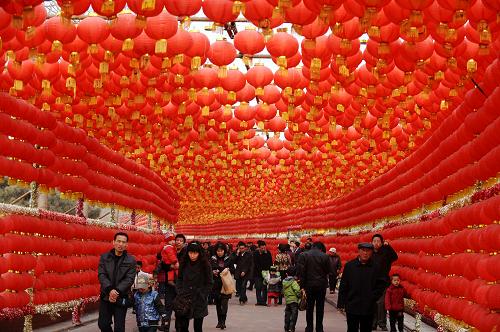 2月27日,在太原市动物园,人们从红灯笼组成的灯廊下走过。元宵佳节临近,山西省太原市动物园内的龙城庙会渐入高潮,大红灯笼、民俗表演,一派喜气盈门、红红火火的景象。新华社记者 燕雁摄