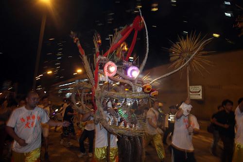 9月22日,香港薄扶林地区举行舞火龙表演。舞火龙是香港中秋节最富传统特色的习俗,80米长的火龙龙身插满了长寿香,在龙鼓音乐配合下欢腾起舞。 新华社记者 吕小炜 摄