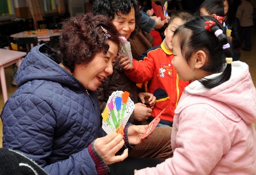 3月6日,杭州朝晖五区幼儿园的一名孩子(前右)在向奶奶献上自己制作的爱心贺卡。在“三八”国际劳动妇女节即将到来之际,杭州市举行才艺比拼、爱心传递、亲子游戏等活动,激发孩子关心母亲、孝敬长辈的感恩情怀。