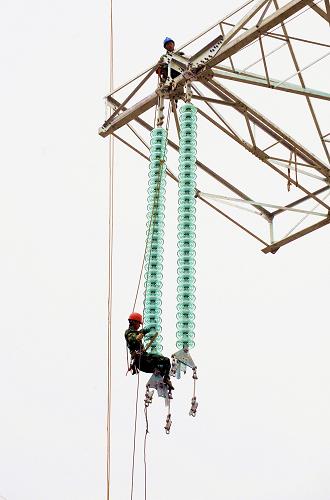 12月1日,福建省第二电力建设公司员工在福建500千伏电网大环网“龙三线”上做最后的施工。新华社记者 张国俊摄