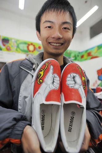 12月3日,一名聋哑学生在展示自己手工彩绘的布鞋。新华社记者欧东衢摄