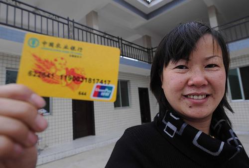 11月18日,在贵州省贵阳市南明区永乐乡水塘村,农民文燕展示农行为她办理的惠农卡。文燕家通过办理惠农卡,于2009年7月获得当地农行4万元的低息贷款,装修和扩建住房,办起了农家乐。2009年1月以来,贵州省农行系统在全省范围内的农村推广惠农卡,该卡具有农户联保、低息、便捷、农行职员全程跟踪管理服务等特点,受到农民欢迎。截至11月18日,全省农行已为82.9万多户农民办理了惠农卡,其中为3.6万户农民授信,授信金额达8.6亿元,农民实际使用金额为7亿多元,这些资金为农民发展生产、增收致富发挥了重要作用。新华社记者 杨楹 摄
