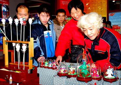 11月28日,观众在北京文博会一家展台前欣赏创意礼品。 为期5天的第四届中国北京国际文化创意产业博览会11月29日顺利闭幕,共有43万人参加,是历届文博会参加人数最多的一次,各类新奇有趣的文化创意产品吸引了众多市民前来参观。据不完全统计,本届文博会共签署文艺演出、出版发行、影视节目制作交易、动漫与网络游戏研发制作等合作意向、协议322个,总金额55.2亿美元。新华社发(韩路 摄)