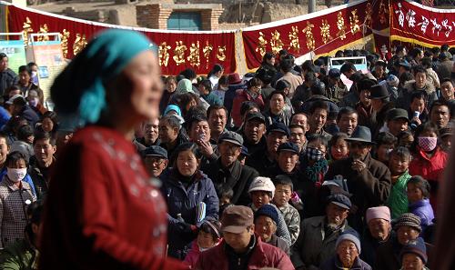 1月22日,青海省互助土族自治县红崖子乡上寨村的村民们在“三下乡”活动现场观看演出。当日,青海省2010年文化、科技、卫生“三下乡”活动在青海省互助土族自治县红崖子乡上寨村启动。青海省教育厅、科技厅等13家单位为上寨村村民捐赠了价值7.5万元的药品、书籍、种子等物品。此外,戏剧团、医疗队、科普宣传队的到来让平日里宁静的小山村充满了节日的气氛。新华社记者 张宏祥 摄