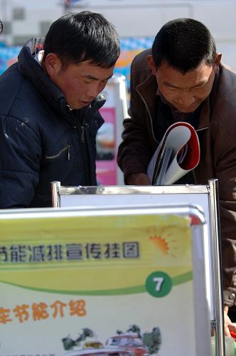 1月22日,“三下乡”活动现场,两位村民正在观看科普知识宣传展板。新华社记者 张宏祥 摄