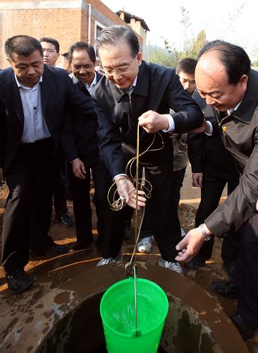 这是3月20日,温家宝在师宗县葵山镇大麦地村农民家的水窖里打水,了解村民饮水保障和卫生情况。 新华社记者 姚大伟 摄