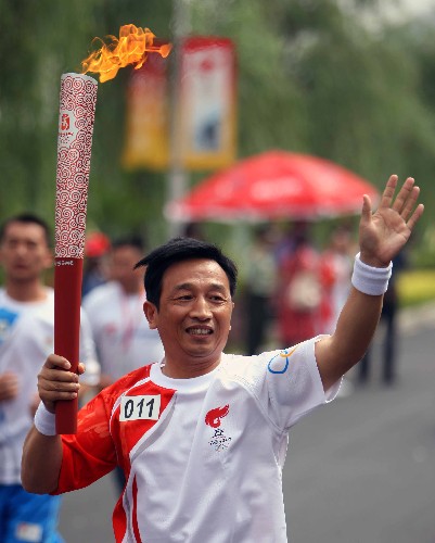 5月30日,奥运火炬手王裕辉手持火炬传递。当日,北京奥运圣火在安徽绩溪传递。 新华社记者邢广利摄