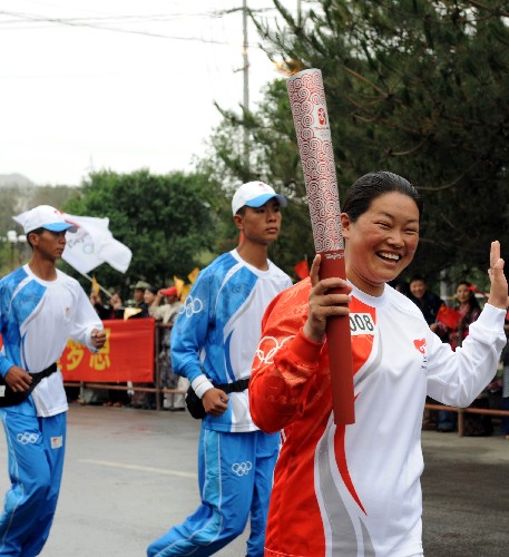 6月21日,火炬手晓红手持火炬传递。当日,北京奥运会圣火传递活动在西藏拉萨举行。 新华社记者觉果摄