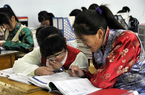 3月10日,营口市第四高级中学西藏班学生琼拉(右)与丹增卓玛在语文课上。辽宁省营口市第四高级中学是国家级重点中等专业学校,1989年设立西藏中专班,开设英语导游、日语导游、会计审计、计算机等专业,至今已为西藏培养了480名拥有各种专业技能的人才。学校为西藏学生提供了最好的学习生活条件,西藏学生在这里愉快地学习生活,健康快乐地成长。新华社记者 张小龙摄