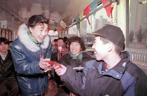 这是“乘客的贴心人”李素丽,大年初一在21路公共汽车上向乘客送上贺年卡,祝大家春节快乐(资料照片)。新华社记者 宋连峰 摄