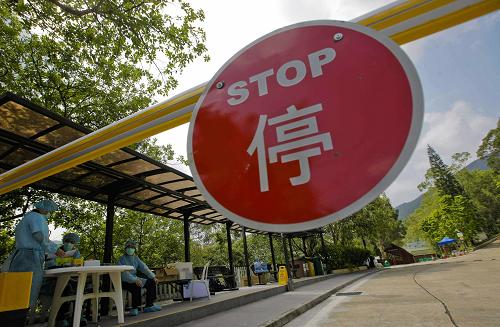 5月4日,香港民安队队员守候在用作隔离中心的麦理浩夫人度假村入口处。新华社记者 周磊 摄