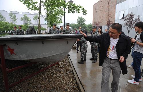 5月8日,工作人员在布置安放冲锋舟的摆放位置。这辆冲锋舟是成都军区驻川某部战士颜建刚于2008年5月13日下午3时驾驶着它担负起开辟映秀灾区第一条水上生命通道的艰巨任务。新华社记者 江宏景摄