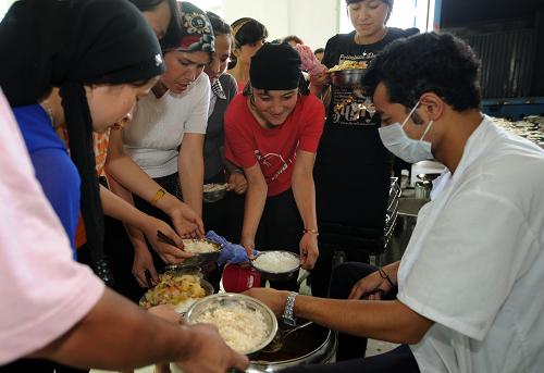 7月7日,新疆籍员工在餐厅排队打饭。新华社记者周文杰摄