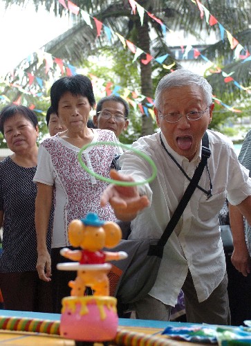 10月7日,一位老人在玩套圈游戏。当日是中华民族尊老敬老的传统节日——重阳节,海口市举办了丰富多彩的敬老游园活动,各种文艺表演和趣味游戏让参加活动的老年人喜笑颜开。新华社记者 郭程 摄