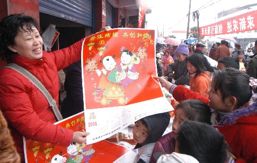 1月24日,参加“三下乡”活动的工作人员向芦溪镇群众送“年画”。新华社发(成潮生 摄)