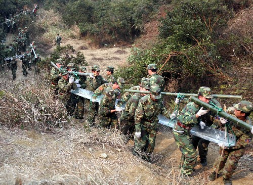 2月14日,南京军区某部官兵在江西上粟县东源乡桥头村搬运钢材。该部500名官兵星夜驰援,抵达当地后迅速投入电力抢修一线,仅用4个小时就将21吨钢材搬运完毕。 新华社发