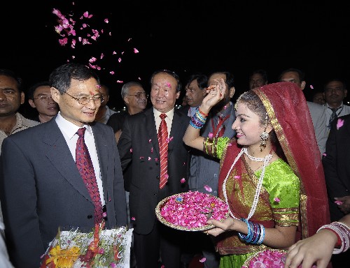     4月17日,身着民族服装的印度女青年撒花瓣迎接