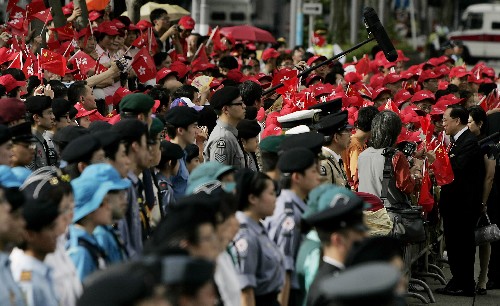 7月1日,香港特区行政长官曾荫权(右)与市民、游客握手致意。当日,为庆祝香港回归祖国11周年,香港特区政府在香港金紫荆广场举行隆重的升旗仪式。 新华社记者 周磊 摄