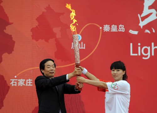 7月31日,第一棒火炬手钱红(右)从中共河北省委常委、唐山市委书记赵勇手中接过火炬。当日,北京奥运圣火在河北省唐山市传递。 新华社记者巩志宏摄